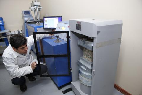 Un técnico observa un dispositivo en un laboratorio con equipo especializado.