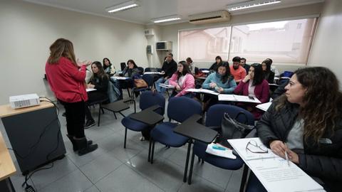 Un grupo de personas asiste a una clase en un salón de clases.