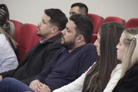 Un grupo de personas sentadas en un auditorio prestando atención a una presentación.