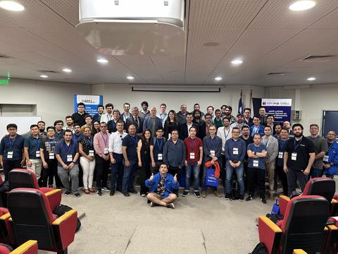 Un grupo grande de personas se reúne en un auditorio para una fotografía en un evento.