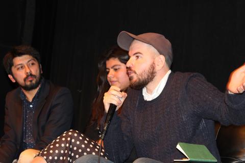 Un grupo de personas discutiendo en un evento en un escenario.