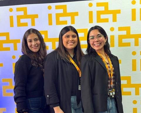 Tres amigas posando juntos con una sonrisa en un evento.