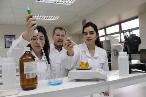 Tres personas en un laboratorio realizando experimentos con sustancias químicas.
