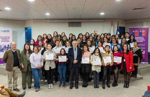 Un grupo numeroso de personas sonrientes posando para una foto en un evento de entrega de certificados.