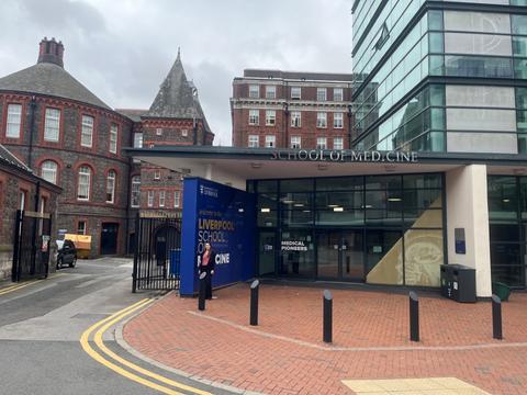 La imagen muestra la entrada de la Escuela de Medicina de Liverpool en un día nublado.