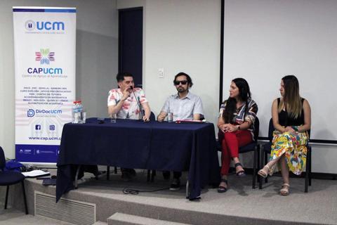 Un panel de discusión con cuatro personas sentadas detrás de una mesa en un evento académico.