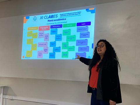 Una persona presenta un menú académico en una pantalla durante un evento educativo.