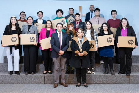 Un grupo de personas posando con cajas de productos HP en un evento.