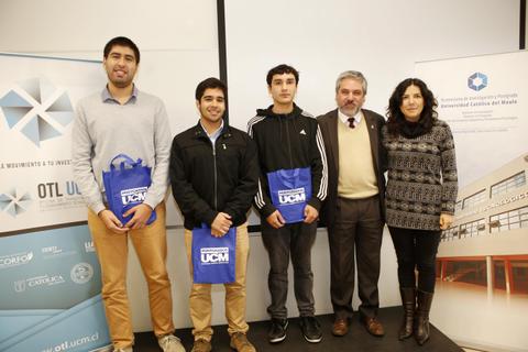 Grupo de estudiantes junto a un profesor en un evento académico.