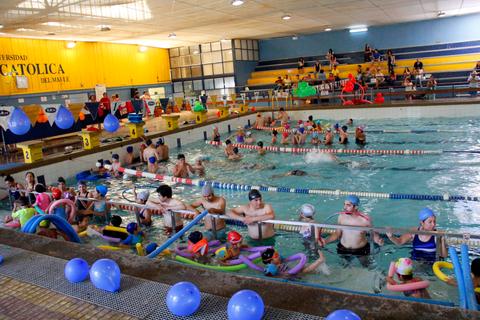 Una piscina llena de personas nadando y disfrutando del agua.
