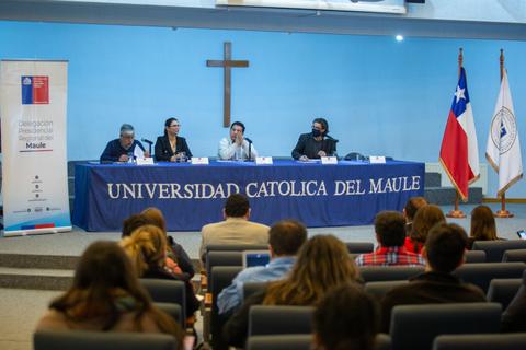 Una mesa de panelistas discutiendo en un evento en la Universidad Católica del Maule.