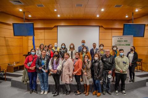 Un grupo diverso de personas posando en un evento dentro de un auditorio.