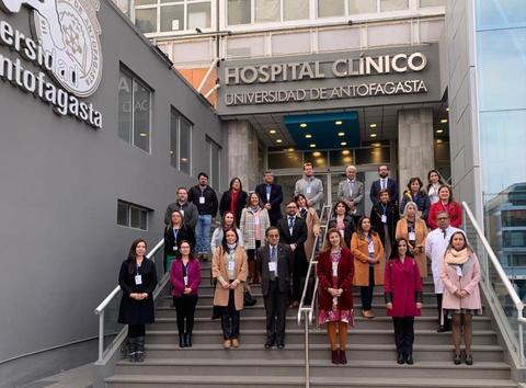 Grupo de personas posando en las escaleras de un hospital clínico.