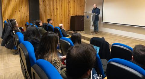 Una presentación en un auditorio con varias personas escuchando atentamente.