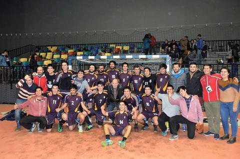 Un grupo de jugadores de un equipo de balonmano posando con sus seguidores en una cancha.