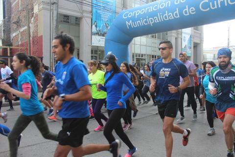 Un grupo de personas corriendo en una carrera al aire libre.