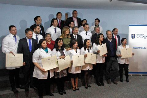 Un grupo de personas graduadas posan con sus diplomas en una ceremonia de entrega.