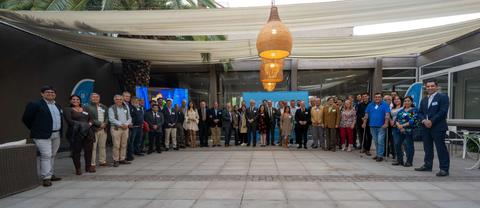 Un grupo de personas posando en un espacio al aire libre bajo una estructura cubierta.