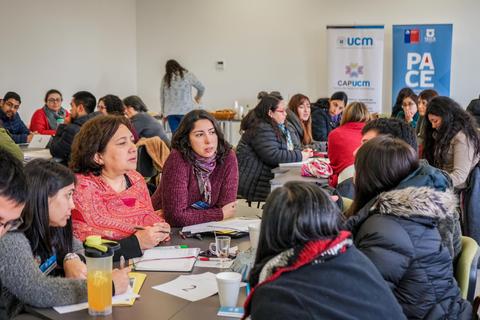 Un grupo de personas participando en una reunión colaborativa en un ambiente académico.