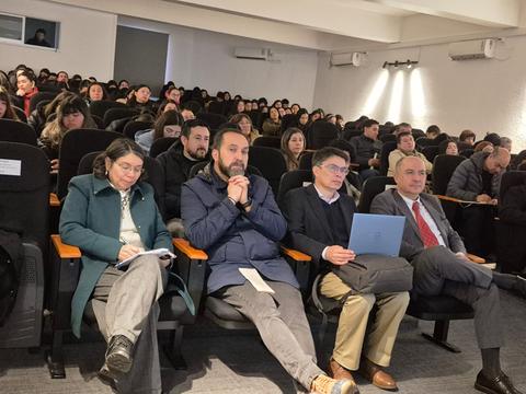 Un grupo de personas sentadas en un auditorio esperando el comienzo de una charla.