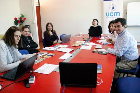 Un grupo de personas reunidas alrededor de una mesa en un entorno de oficina.