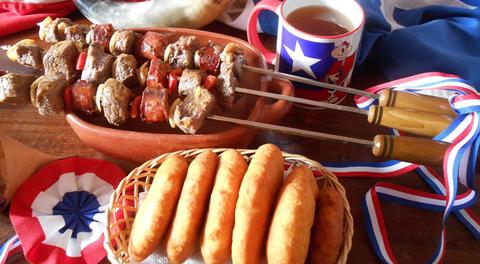 Una deliciosa presentación de brochetas de carne acompañadas de pan frito y una taza de bebida caliente.
