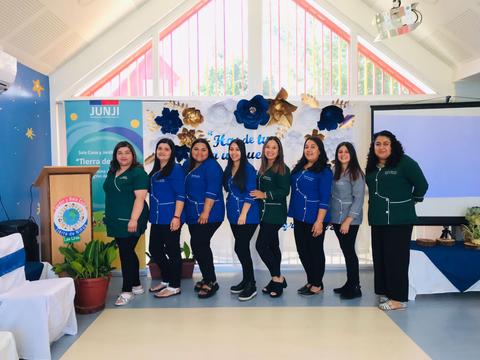 Un grupo de mujeres posando juntas en un evento con decoración colorida.