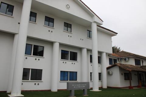 Edificio moderno de la Facultad de Medicina, con columnas en la entrada y un diseño arquitectónico distintivo.