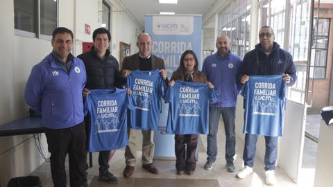 Un grupo de personas sosteniendo camisetas azules en un evento relacionado con una corrida familiar.
