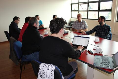 Una reunión de varias personas sentadas alrededor de una mesa en un entorno luminoso.