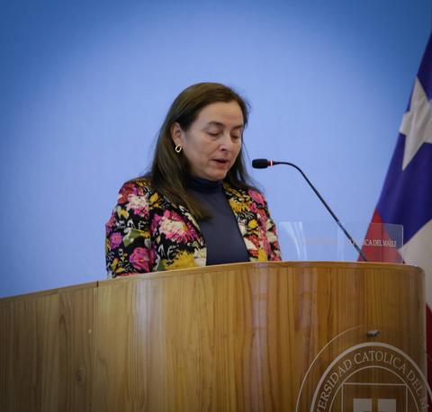 Una mujer habla desde un podio en un evento formal.