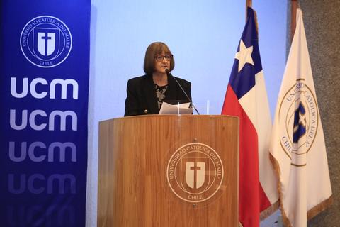 Una mujer pronuncia un discurso en un podio durante un evento en la Universidad Católica del Maule en Chile.