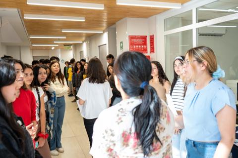 Un grupo de estudiantes conversando en un pasillo amplio y luminoso.