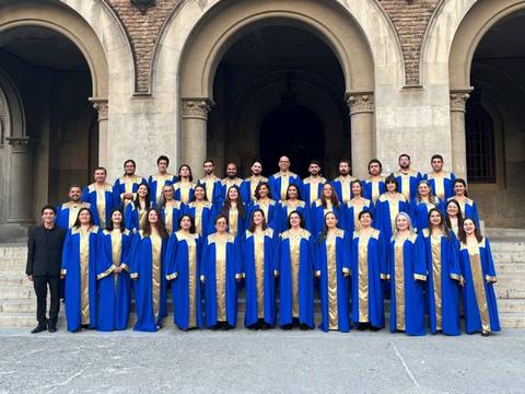 Un grupo de personas vestidas con túnicas azules y doradas se agrupan frente a un edificio histórico.
