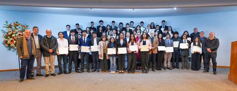 Un grupo de estudiantes chilenos posando orgullosos con sus certificados en una ceremonia de premiación.