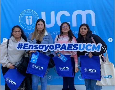 Cuatro jóvenes sostienen un cartel con la frase '#EnsayoPAESUCM' frente a un fondo con el logo de la Universidad Católica del Maule.