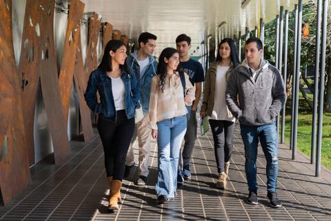 Un grupo de seis jóvenes caminan juntos por un pasillo.