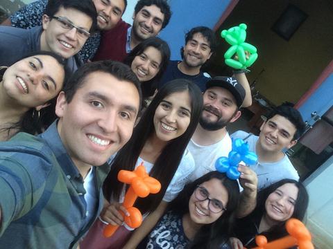 Un grupo de amigos sonríen mientras posan para una foto con globos de colores.