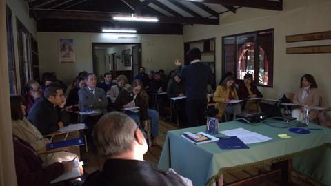 Un grupo de personas participa en una charla o taller en un ambiente acogedor.