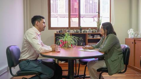 Una conversación entre dos personas sentadas en una mesa