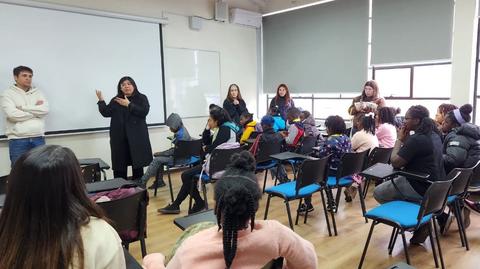 Un grupo de personas asiste a una charla en un aula con un ambiente informal.