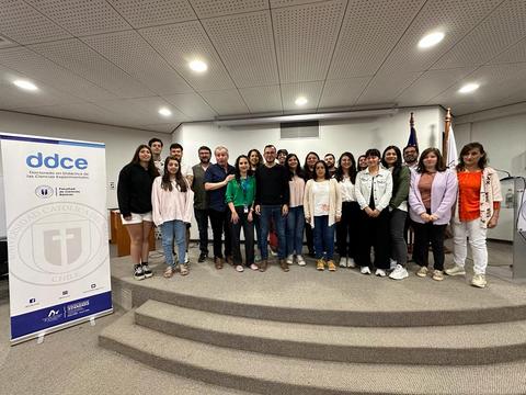 Grupo de personas posando juntas en un evento en un auditorio.