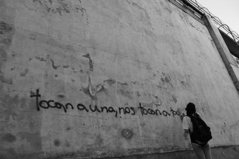Una persona observa una frase escrita en una pared.