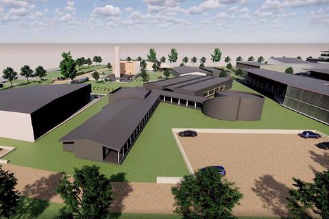 Una vista aérea de un complejo arquitectónico moderno rodeado de áreas verdes.