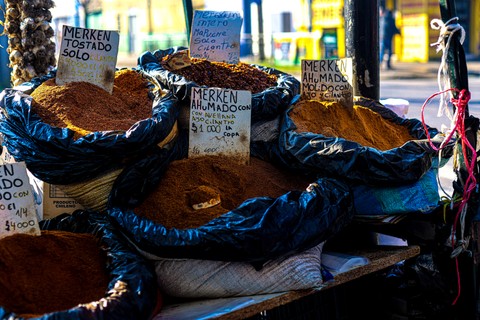 Un puesto de spices con sacos de merken tostado y ahumado en un mercado chileno.