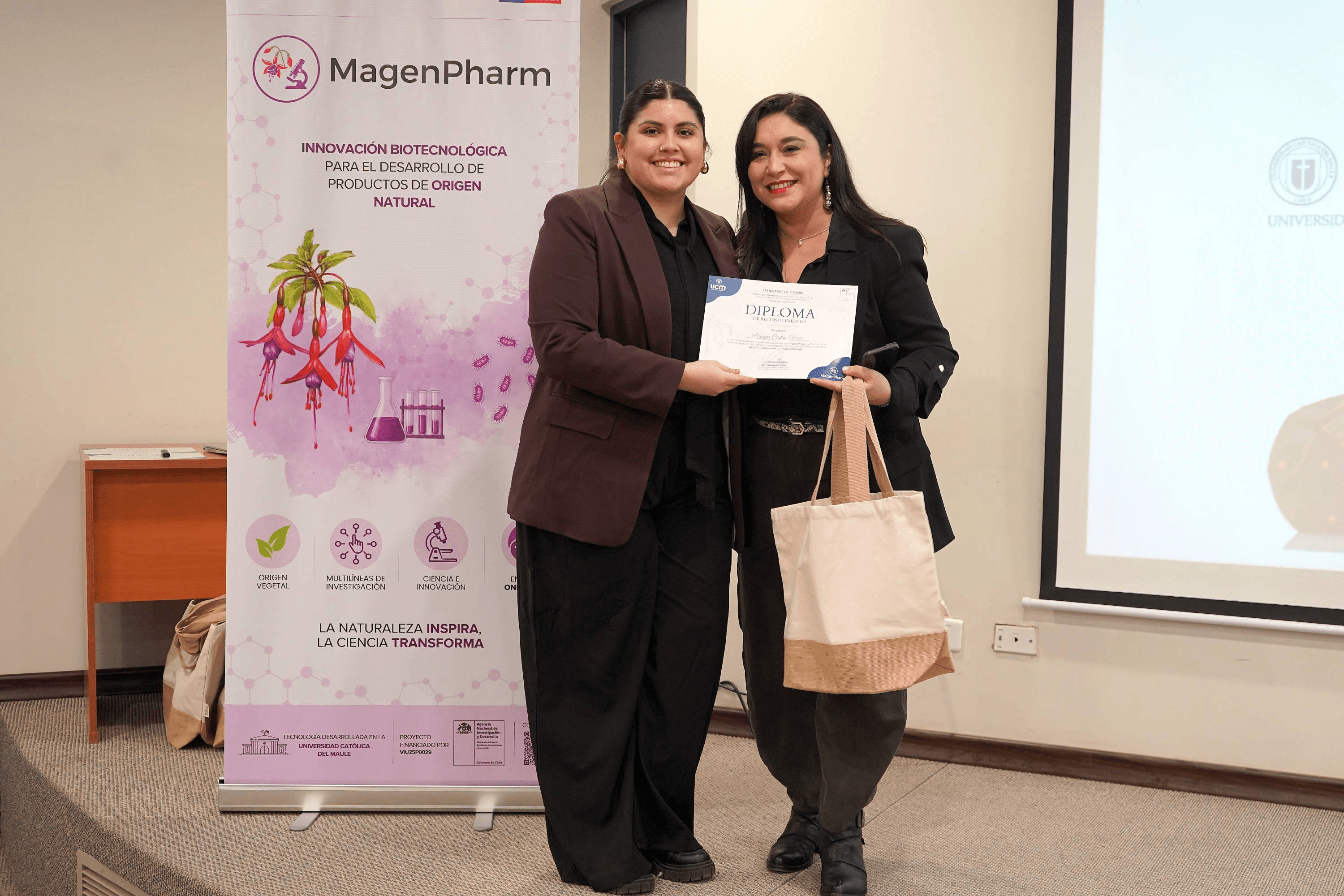 Dos mujeres posando felices con un diploma en un evento de MagenPharm.