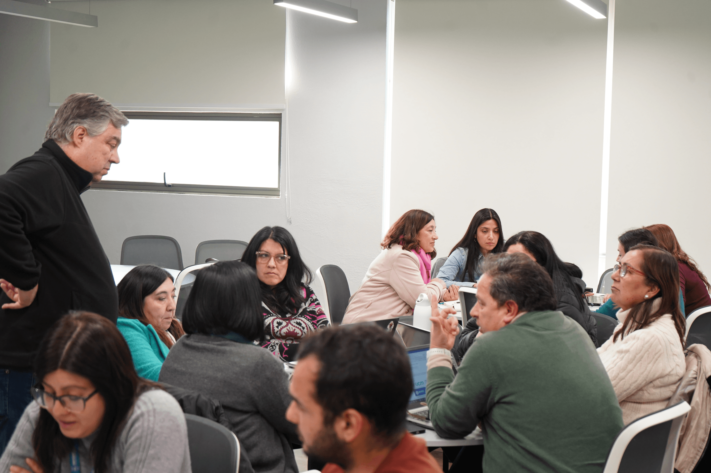 Un grupo de personas participa en una actividad de trabajo en equipo en una sala de capacitación.