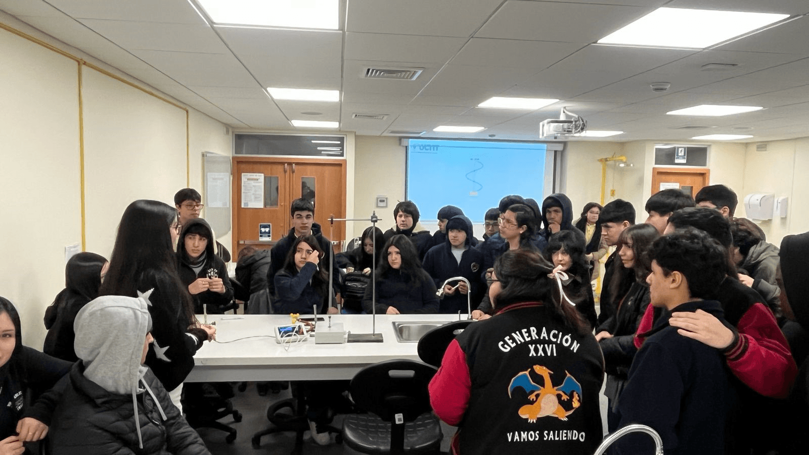 Un grupo de estudiantes en un aula participando activamente en una clase.