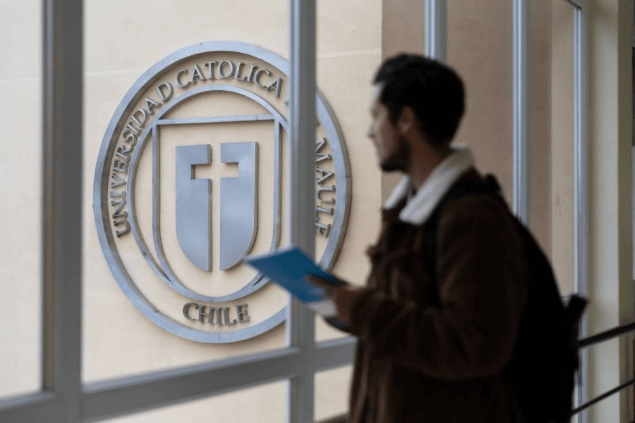 Un estudiante observa el emblema de la Universidad Católica en Maipú, Chile.