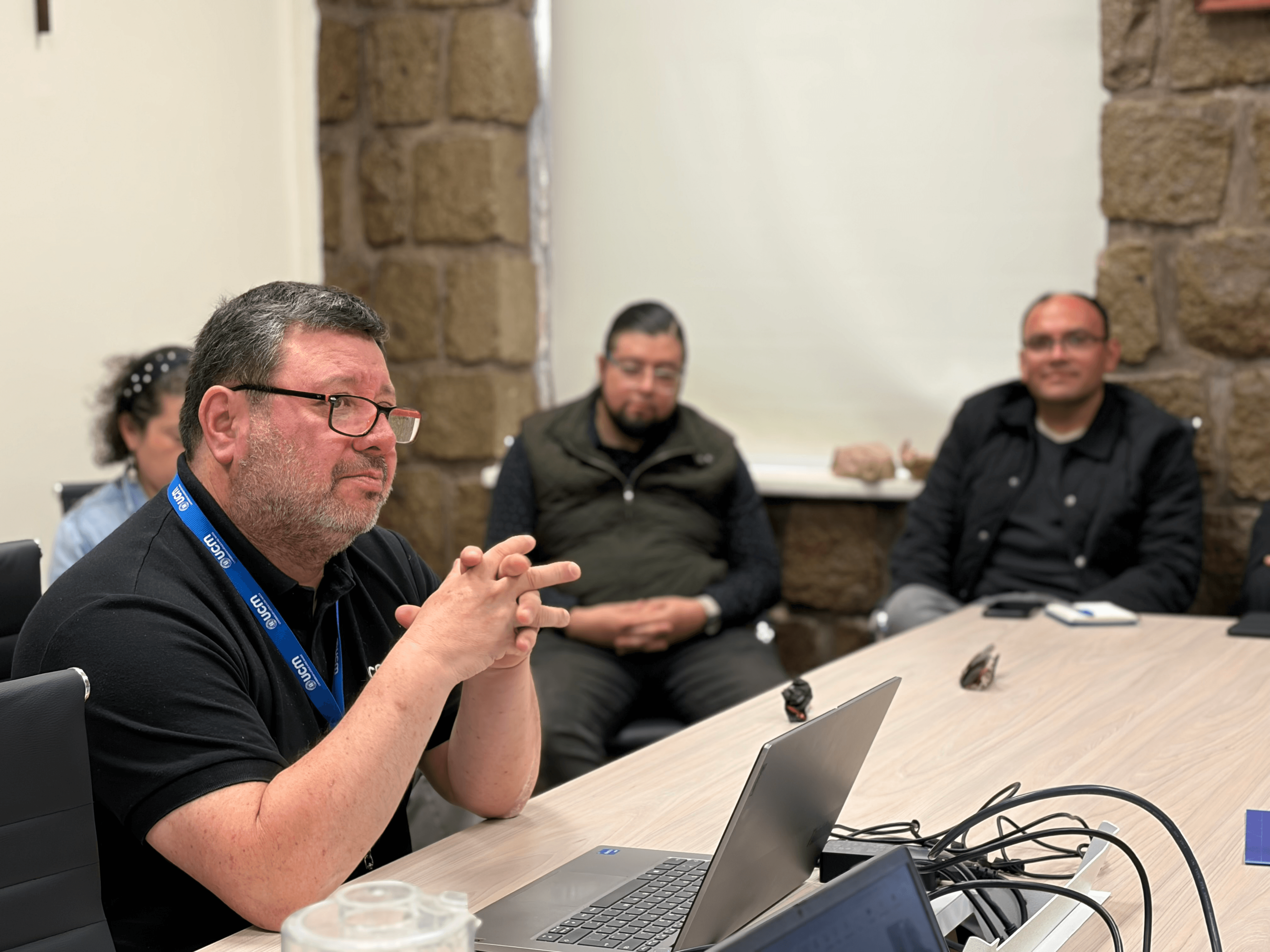 Un grupo de personas en una reunión discutiendo alrededor de una mesa.